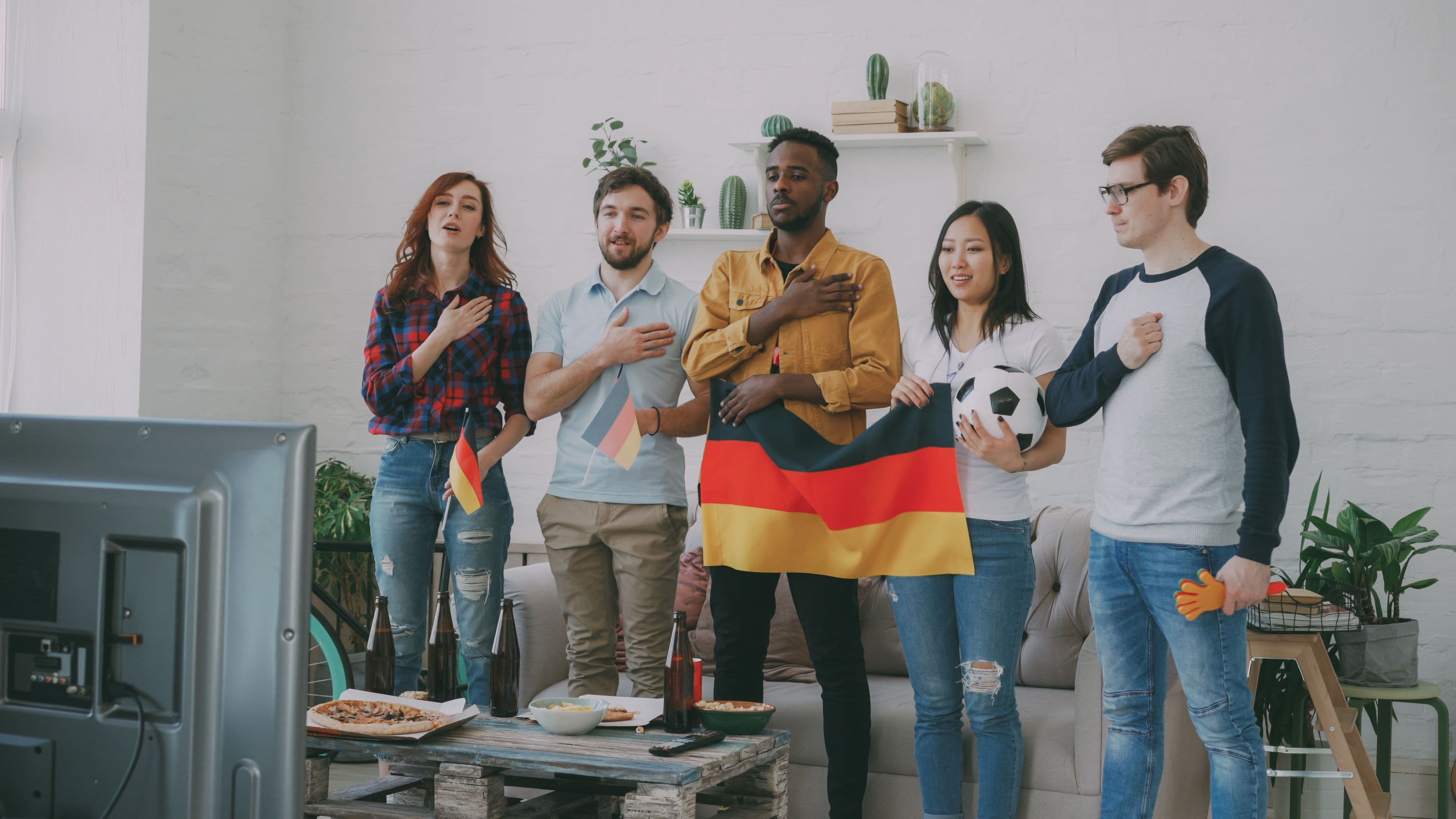Un groupe d'amis suit un match de football en direct depuis leur salon.